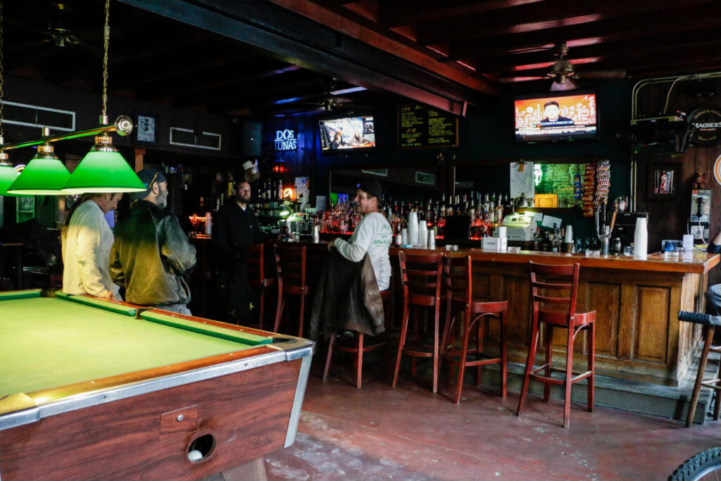 Molly's Bar on Toulouse with customers sitting at the bar and pool table.